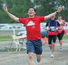 An elated runner crosses the finish line during the Millarville Run to the Farmers&#8217; Market Half Marathon last year. The second annual event will kick off this