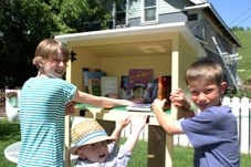 Nina, Tommy and Leo Scott are excited to have people in town start using the Little Free Library outside of their home on Elma St.