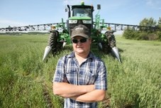 Okotoks-area farmer Mike Imler stands in front of his crop sprayer in a field south of Highway 7 on July 15. Imler is encouraged by the increase in hail insurance coverage