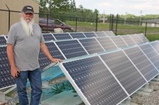 Dusty Williams, Town of Turner Valley environmental services and recycle supervisor, stands beside the solar array system near the Town&#8217; s water treatment plant last