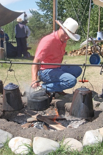 Bar U Ranch National Historic Site volunteer Steve Weston checks the coffee cooking over the campfire during the Roundup of Memories event last year. This year&#8217; s event 