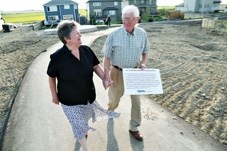 Dr. Grant Hill walks with his wife Sue through the future site of the park recently named after him.