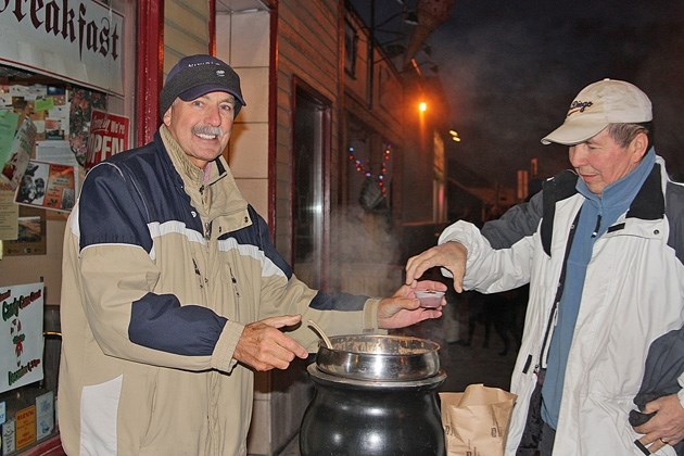 Black Diamond Bakery and Coffee Shop&#8217; s George Nielson serves up chili to Calgarian Ron Isbister during Light Up Black Diamond in 2012. This year&#8217; s event takes