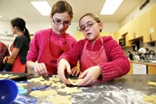 Oilfields High School Grade 7 students Emily Voth, left, and Sarah Levine bake cookies for students to give to people in the community during the school&#8217; s Spirit of