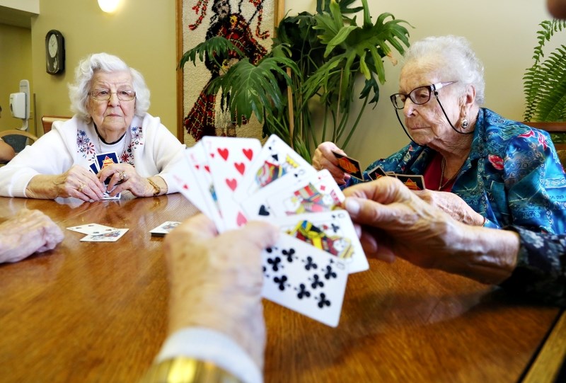 Beatrice Catt, left, and Amy Vetters play cards at the High Country Lodge in Black Diamond. The lodge will receive $410,000 in fire-protection improvements as part of a
