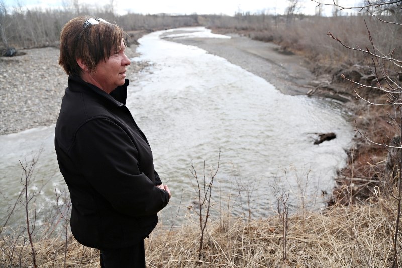 Turner Valley mayor Kelly Tuck stands beside the Sheep River, which is receiving more than $135,000 in Provincial funding for post-flood repairs to riparian areas.