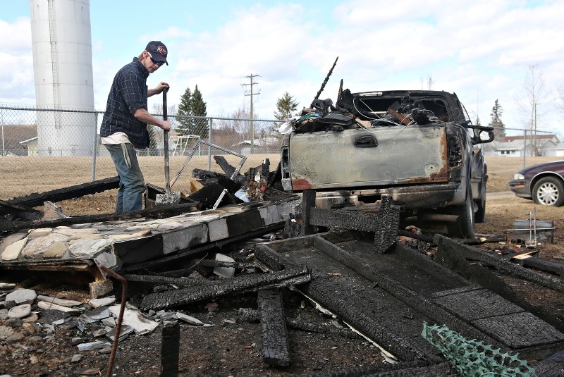 A man cleans up debris after a shed caught on fire in Black Diamond&#8217; s Maplewood last week. Firefighters say the fire risk level is currently rated very high.