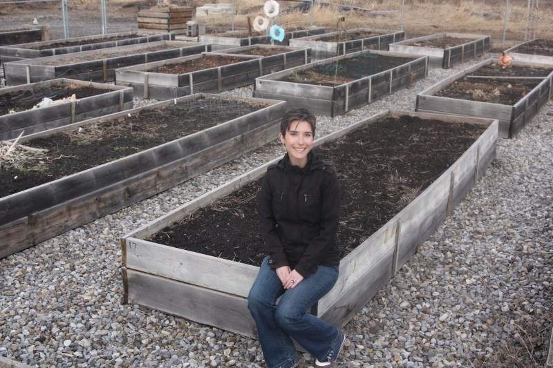 Diamond Valley Community Garden subcommittee chairperson Meg Porter sits on one of the 77 garden plots last weekend. Registration for the plots takes place at the Sheep River 