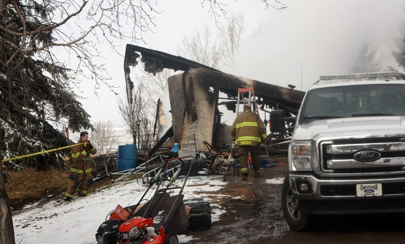 Okotoks Fire Department members tape off the scene of a fire which destroyed a home approximately 2km south of town along Dump Road about 4:30 a.m. Easter Sunday. The cause