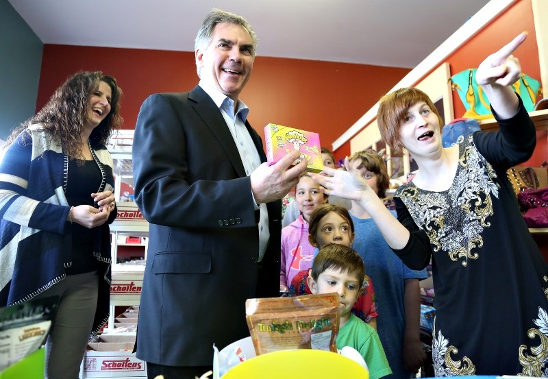 Premier Jim Prentice stops at Sheena&#8217;s Sweet and Such in High River and visits with PC candidate Carrie Fischer and owner Sheena Small while children fill candy baskets.