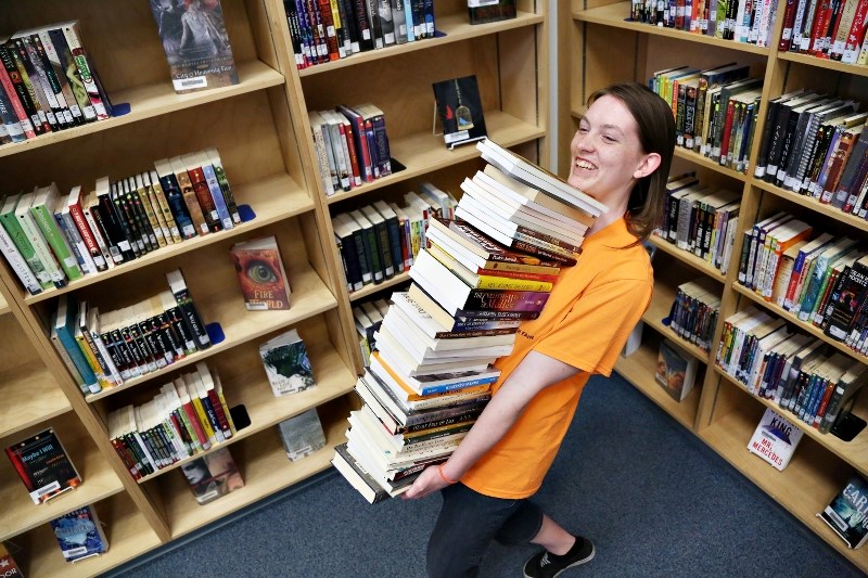Oilfields High School student Elise Denning carries books that will be available for sale in the school&#8217; s annual book sale April 29 and 30 from 8:30 a.m. to 7:30 p.m.