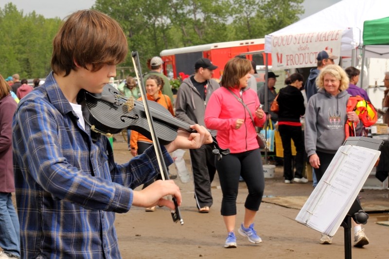 Thomas Garchinski plays for the crowds at the Millarville Farmers Market on opening day last year. The market is opening for the season on June 13.