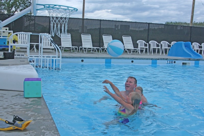 Six-year-old Ella Kaack takes a shot while dad Ian and sister Lily look on in the Dr. Lander Memorial Outdoor Swimming Pool last week. The Town received $10,000 from the