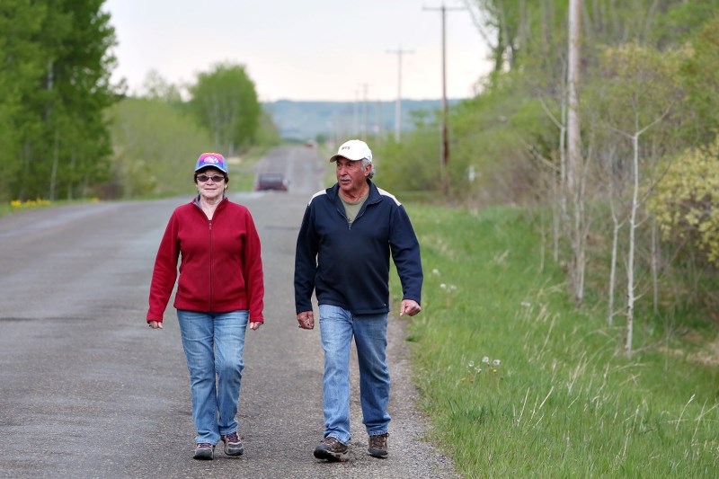 Marg Walz and Harvey Fry walk on 418 Ave. W earlier this summer. A pathways, parks and recreation committee is compiling information from a public survey to determine