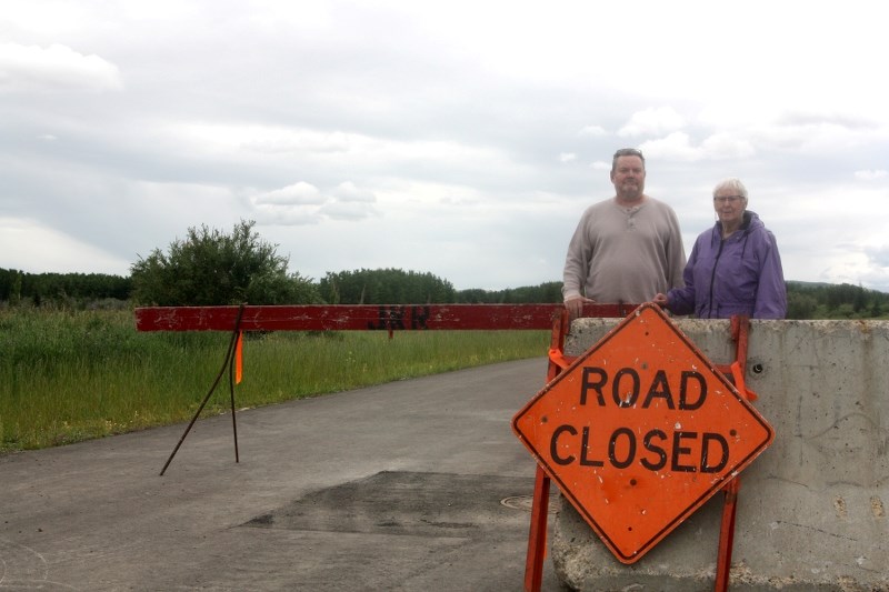 Bill Rowe and Joy Hinman stand at a barrier on the south end of Royalite Way, which will be removed on Aug. 31 in conjunction with the closure of a portion of Imperial Drive