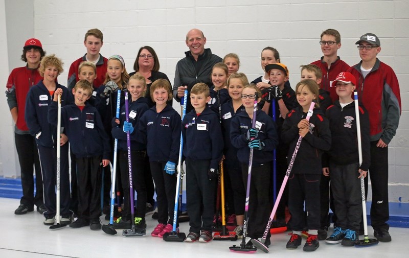 Olympic gold medallist Kevin Martin, middle, is seen with members of the Okotoks Junior Curling Academy on Oct. 3. Martin was on hand to announce Okotoks as hosts of the 2016 