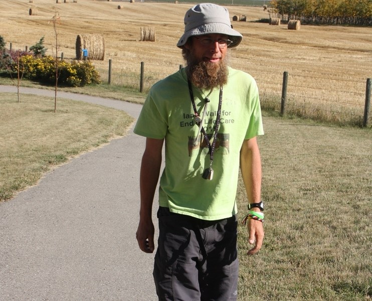 Ian Bos takes a stroll at the Foothills Country Hospice. Bos, who is walking across Canada to raise funds for palliative care, visited the Okotoks facility on Sept. 28.