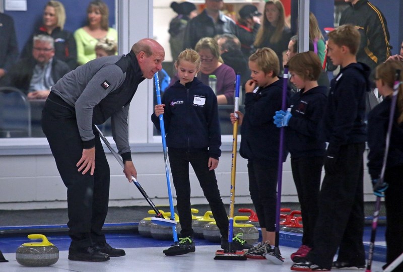 Olympic gold medallist Kevin Martin shows the ropes to a group of young curlers on Curling Day in Okotoks on Oct. 3.