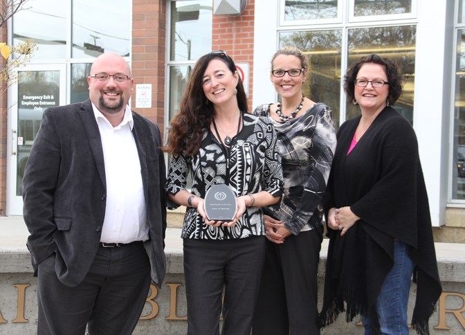 Town of Okotoks economic development team members show off the Chinook Country Tourism Municipality of the Year Award outside the municipal centre on Oct. 13. The Town was