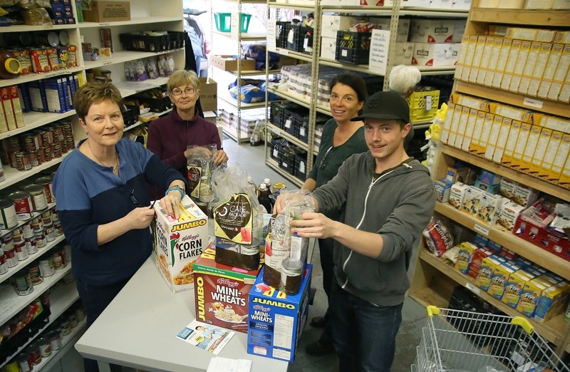 From the left, Okotoks Food Bank volunteers Bev Matheson, Patty Littlewood, Carol Nerland and Ricky Jones sort donations on Oct. 21.
