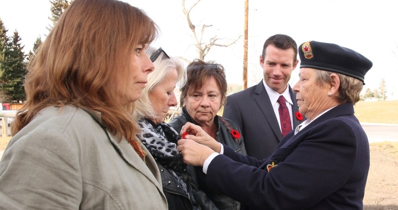Royal Canadian Legion Turner Valley Branch #78 first vice-president Linda Macaulay pins a poppy on Longview mayor Carole MacLeod&#8217;s lapel at the legion&#8217;s poppy