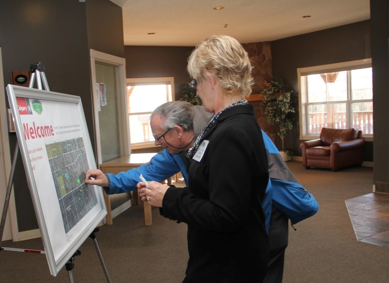 MD resident John Thorpe places a sticker to identify his property on a regional map with MD of Foothills planning assistant Donna Thurston at the City of Calgary and MD of