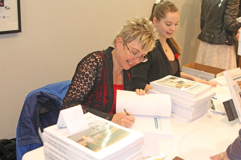 Calgary author Anne Gafiuk signs copies of her book She Made Them Family: A Wartime Scrapbook from the Prairies at the RPAC on Nov. 8. The book was inspired by the late Alice 