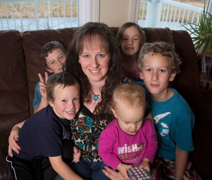 Kira Perdue, and her children, clockwise from front left, James, William, Carys, Dallas, and Tierney sit in their living room. Kira&#8217; s husband RCMP Const. Jeremy Perdue 