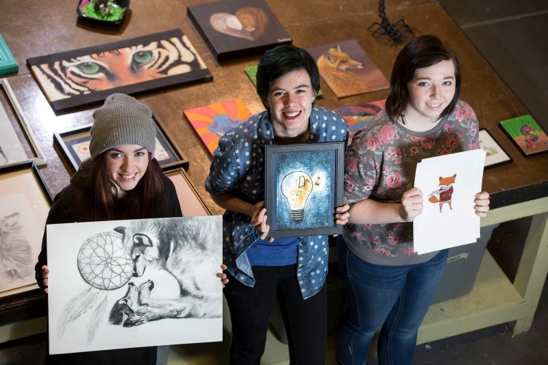 Alberta High School of Fine Arts students, from left, Antalya Speed, Kathryn Wall and Erin May show off some of their artwork that will be displayed at the Sheep River