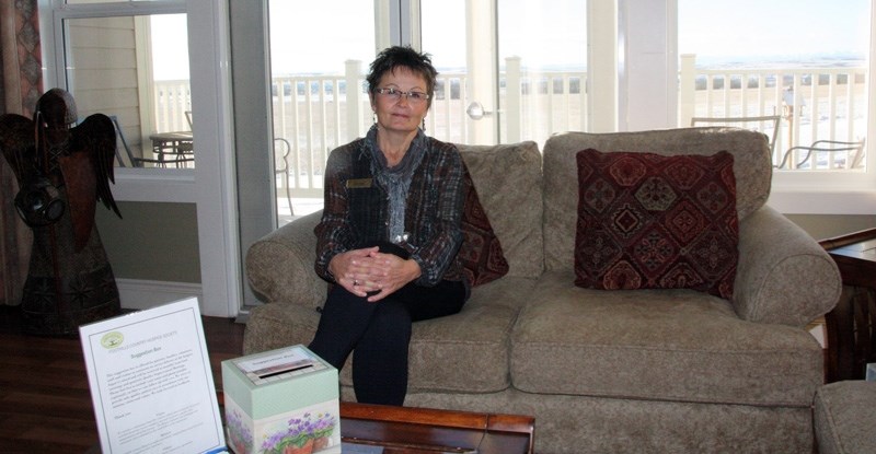Dawn Elliott, executive director of the Foothills Country Hospice, sits on a couch the facility hopes to replace through funds raised by the Western Wheel Cares campaign.