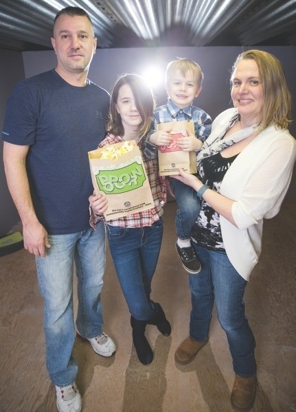 Craig Grillo and Heather Colvin with their chidren Marissa and Zeno in a space that will soon be a private movie theatre for families with children.