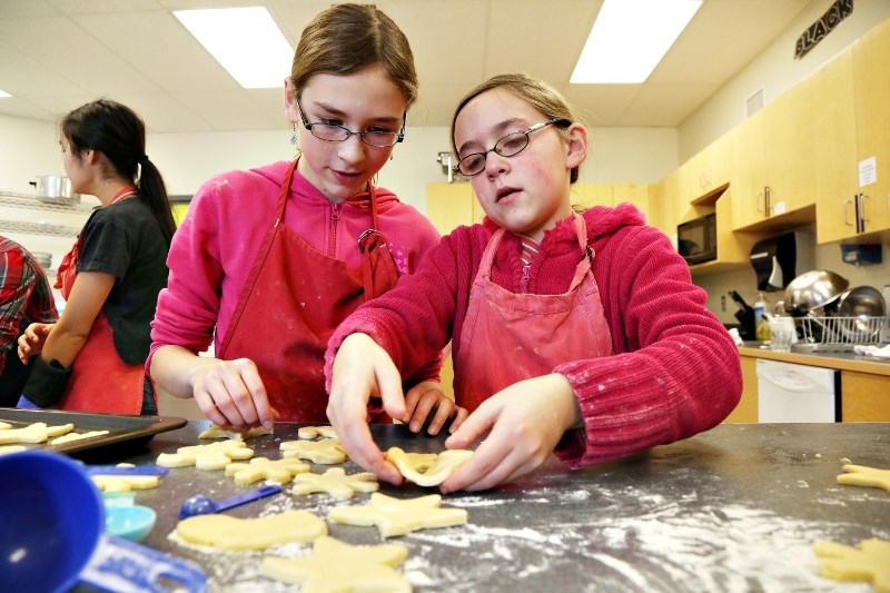 Students Emily Voth and Sarah Levine bake cookies at Oilfields High School which were given out to people in the community during the 2014 Spirit of Giving event.