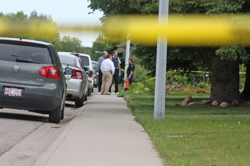 RCMP investigate the scene of a 2010 shooting outside an Okotoks home. A fatality inquiry has found the police were justified in shooting Corey Lewis after he walked out of