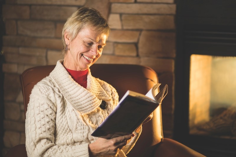 Foothills cowboy poet and librarian Doris Daley with a book of poetry in Turner Valley&#8217; s Sheep River Library on Dec. 30. The library has several programs, such as the