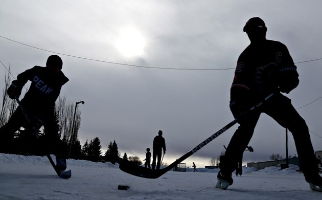 Hockey players pass a puck around on the ice behind the Okotoks Recreation Center during last year&#8217;s Family Day activities.