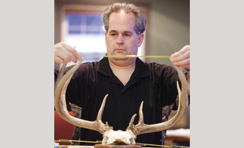 Official Boone and Crockett Scorer Jim Clarke measures antlers at the Okotoks Fish and Game Club&#8217; s antler scoring event at the Crystal Shores Beach House on Feb. 26.