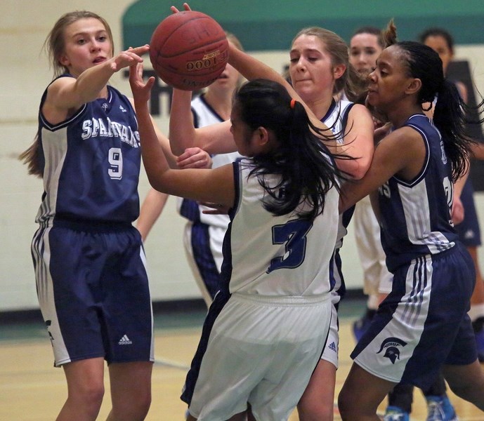 Strathcona-Tweedsmuir Spartan Hadley Rawling, left, and Emy Udoh battle for a loose ball in the team&#8217; s 53-52 win over Holy Cross Collegiate at the 2A South Central