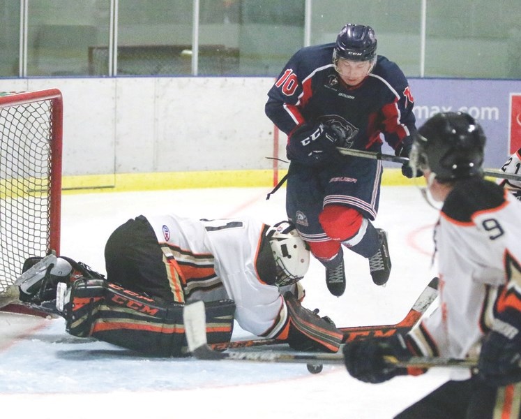 Okotoks Bisons forward Josh McCullough leaps over Coaldale Copperhead goalie Dillan Kelly in search of a rebound. Coaldale doubled up Okotoks by a 4-2 score in the HJHL