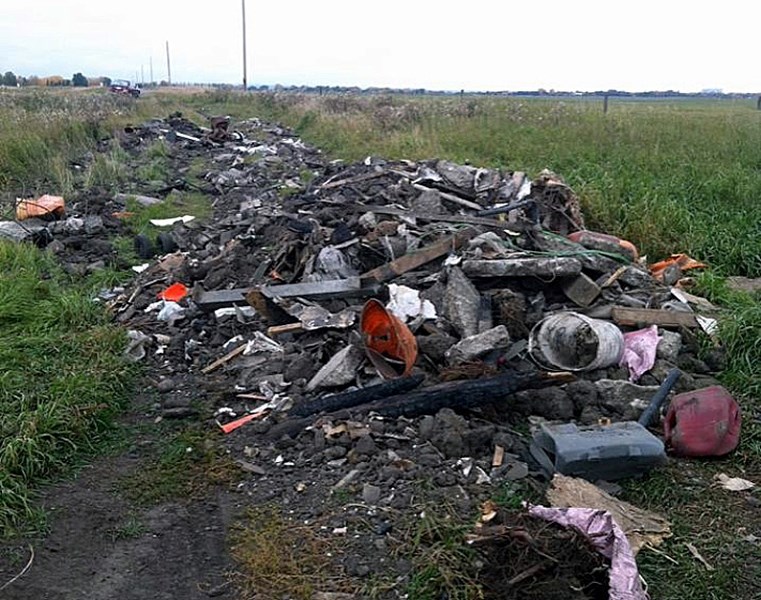 A large load of waste and debris from a construction or demolition site sits in the ditch near 112 Street East and Dunbow Road.