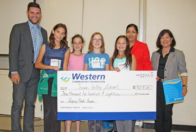 From left, Andrew Cilinski, regional director of Western Financial Group, presents $3,218.25 to Turner Valley School, received by students Maya Perez-Robinson, Ciara Irvine,