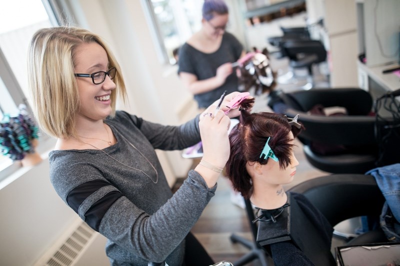 Grade 12 students Jordan Sicotte, left, and Landry Stasiuk practice hair styling techniques in the new cosmetology classroom on Oct. 20. The renovations have been underway
