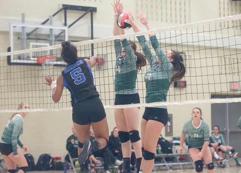 Holy Trinity Academy Knights Danielle Forester and Mallory McQuillan try to get their hands on a spike from the County Central Hawks in the FAC semifinal on Nov. 7 at HTA