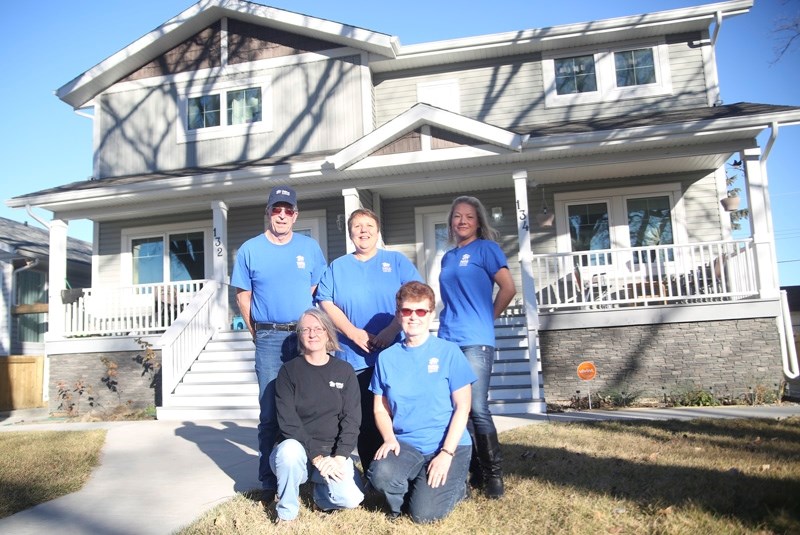 Volunteers John MacLeod, Marilyn Boake, Corene Loewen, Jennifer Payne and Val MacLeod stand in front of a High River duplex built by Habitat for Humanity&#8217;s Southern