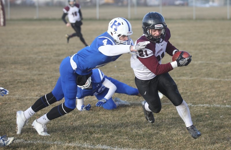 Foothills Falcon Ben Tighe fends off the tackle of Hunting Hills Lightning James Nobbs in the Tier II South Final on Nov. 19. Foothills won 35-14 to advance to the Alberta
