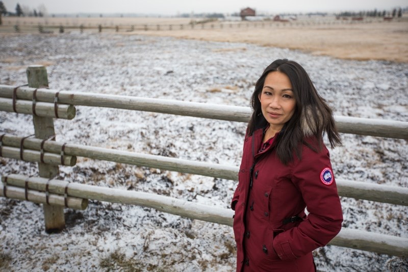 Kelly Choi in front of the fire-damaged grass near her home on Nov. 19. After a neighbour&#8217;s barrel burn got out of control in the wind on Nov. 10 and swept across the