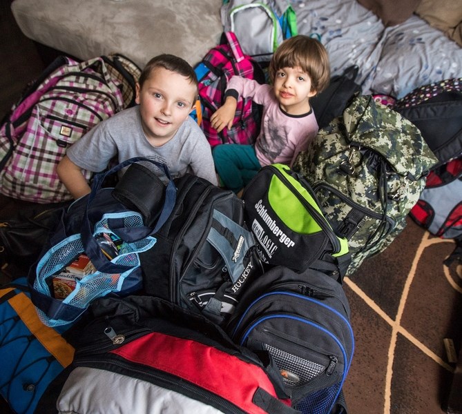 Everest Austin, left and Hannahlyn Clifford sit amidst the 30 backpacks they have prepared to deliver to the homeless on Nov. 19.