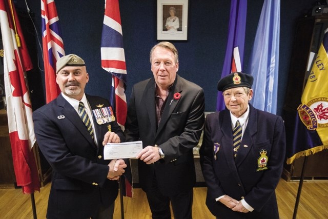 Turner Valley Legion President Ray MacGregor, left, and First Vice-President Linda Macaulay accept a cheque from Livingstone-MacLeod MLA Pat Stier for $10,000 from the