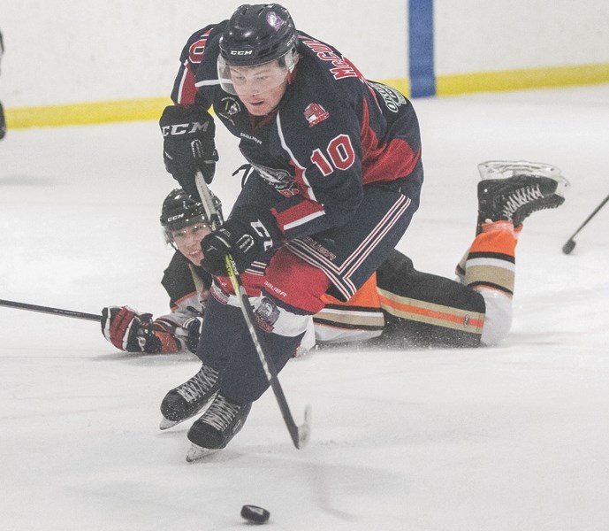 Okotoks Bisons forward Josh McCulloch stick handles by a Coaldale Copperhead earlier this season. The winger leads Okotoks with 53 points in 26 games.