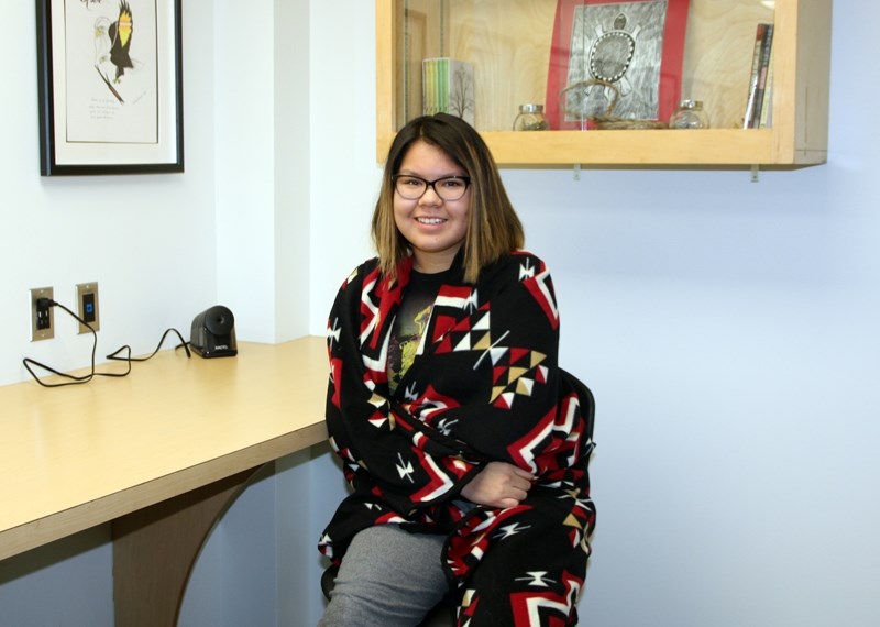 Oilfields High School student Chloe Dixon drapes her self in a First Nations blanket at the school&#8217; s library. The Grade 11 student was a recipient of the Aspire
