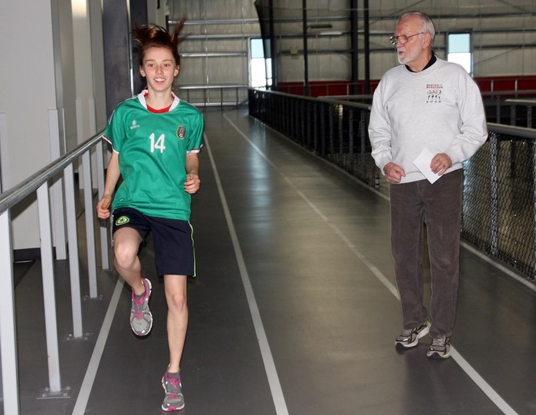 Okotoks runner Rosie Bouchard does some drills under the instruction of Richard Ellum of the Big Rock Runners on Jan. 4 at the Crescent Point Regional Field House.